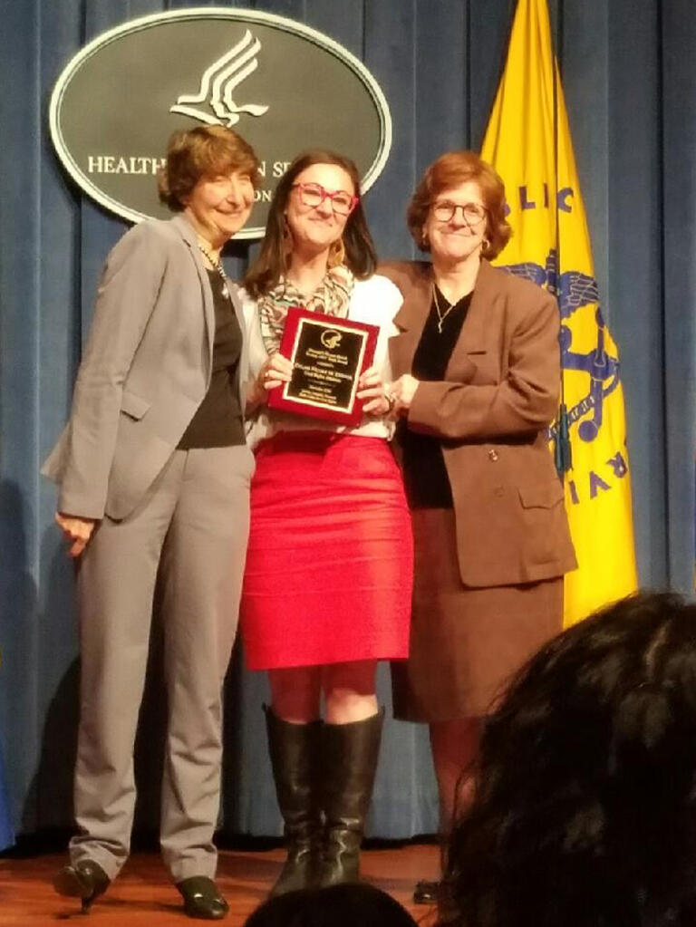 Dylan de Kervor onstage receiving an award from Health and Human Services