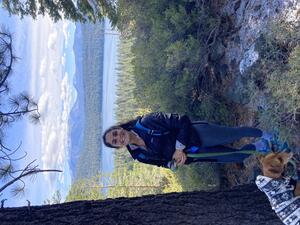 Sarah Pierluissi with dog on leash in foreground; forest and lake in background