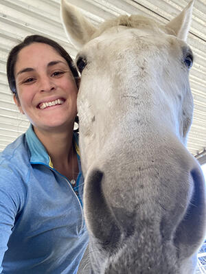 Sarah Pierluissi smiling next to horse